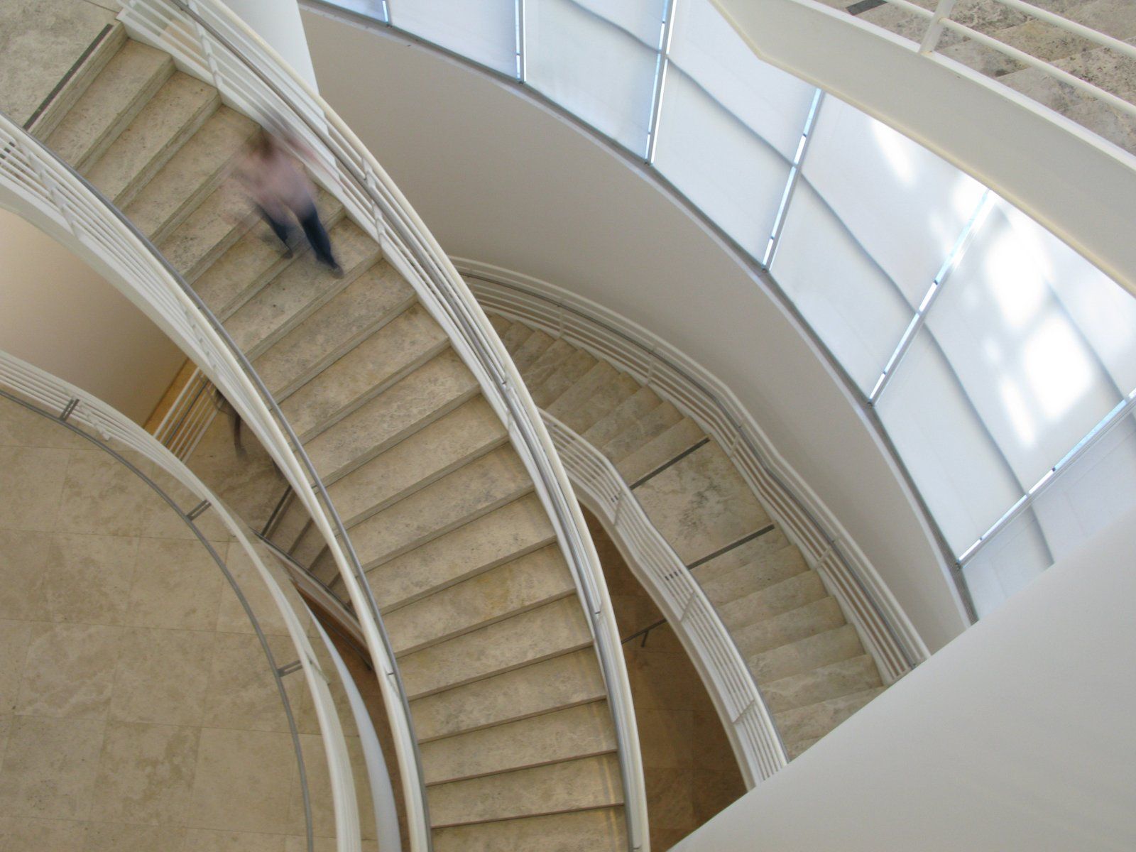 A spiral staircase seen from above, sweeping down through the building
